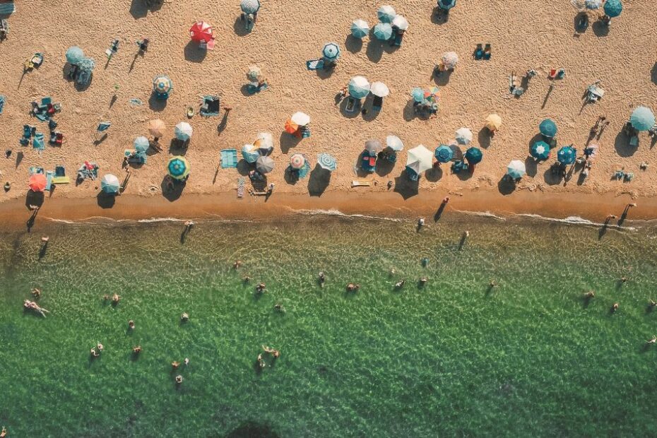 Plage vue d dessus avec vacanciers représentant les destintions tendances de l'été