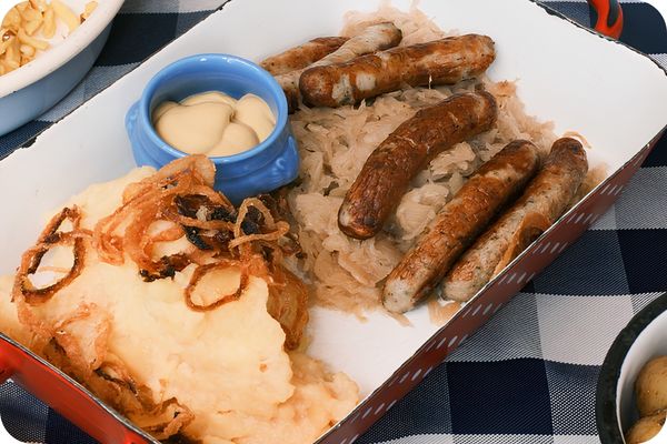 Saucisses, choucroute et purée alsaciennes dans un moule en terre cuite