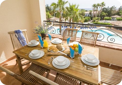 Petit-déjeuner sur une terrasse avec vue sur la piscine