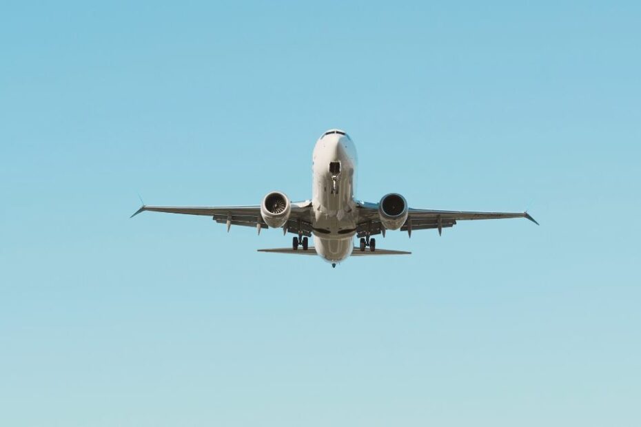 Avion de ligne en plein vol dans un ciel bleu pour illustrer le coût des transports et partir en vacances pas cher