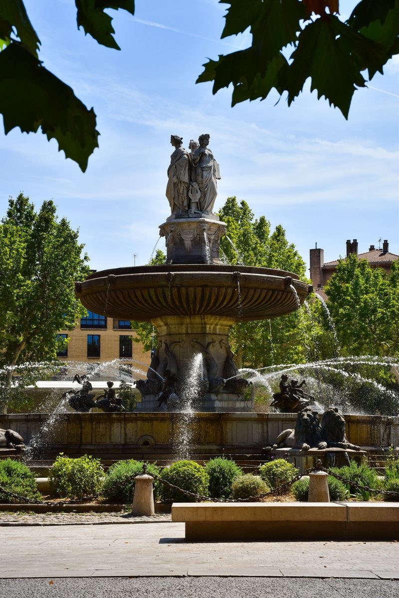 La fontaine ombragée d’une place d’Aix-en-Provence, sous un ciel bleu