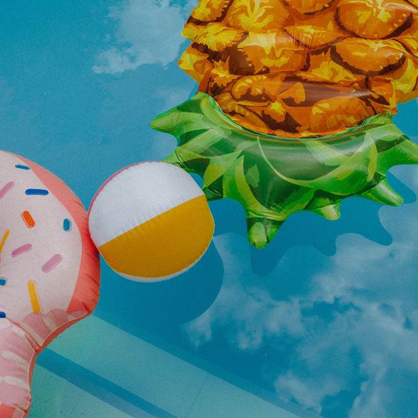 Bouées colorées et ballon flottant sur l’eau bleue d’une piscine