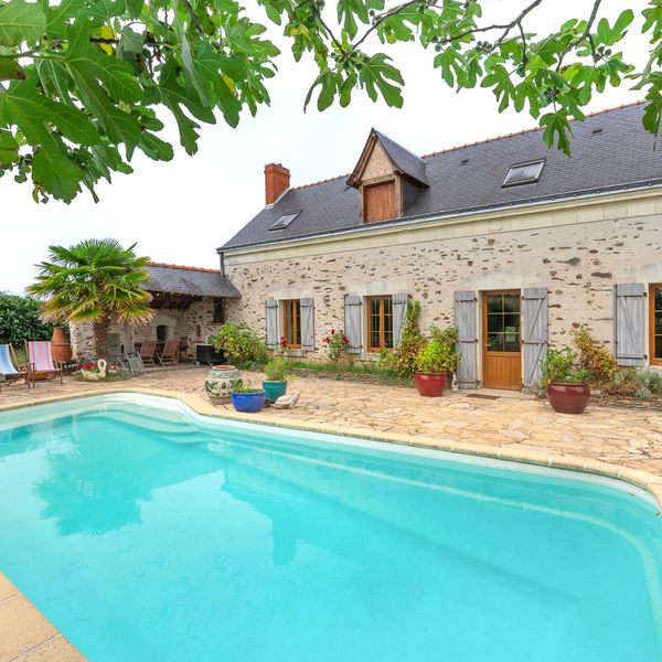 Une maison de campagne en pierre avec sa piscine au soleil